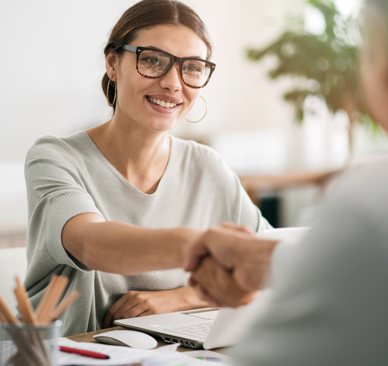 Smiling woman shaking hands with advisor during home loan consultation